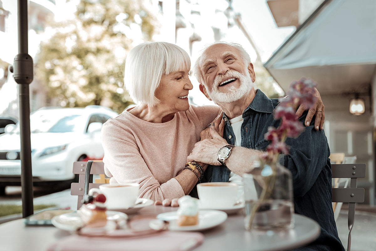 SoCo Village | Happy senior couple sitting outside enjoying coffee