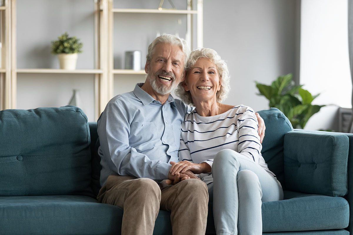 SoCo Village | Family portrait smiling mature couple sitting on couch