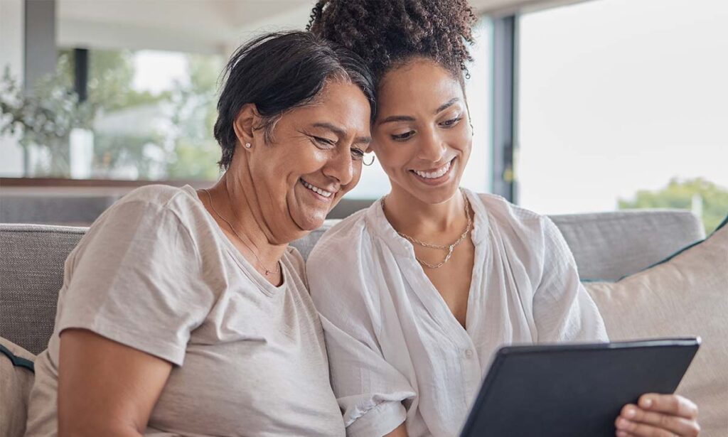 SoCo Village | Senior mom with daughter bond while looking at a tablet