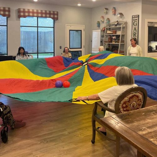 SoCo Village | Seniors playing game with parachute